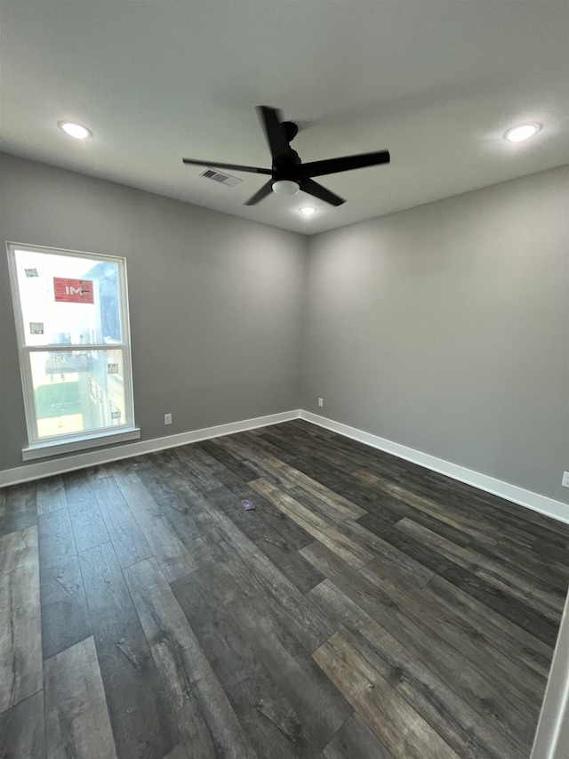 spare room with ceiling fan and dark wood-type flooring