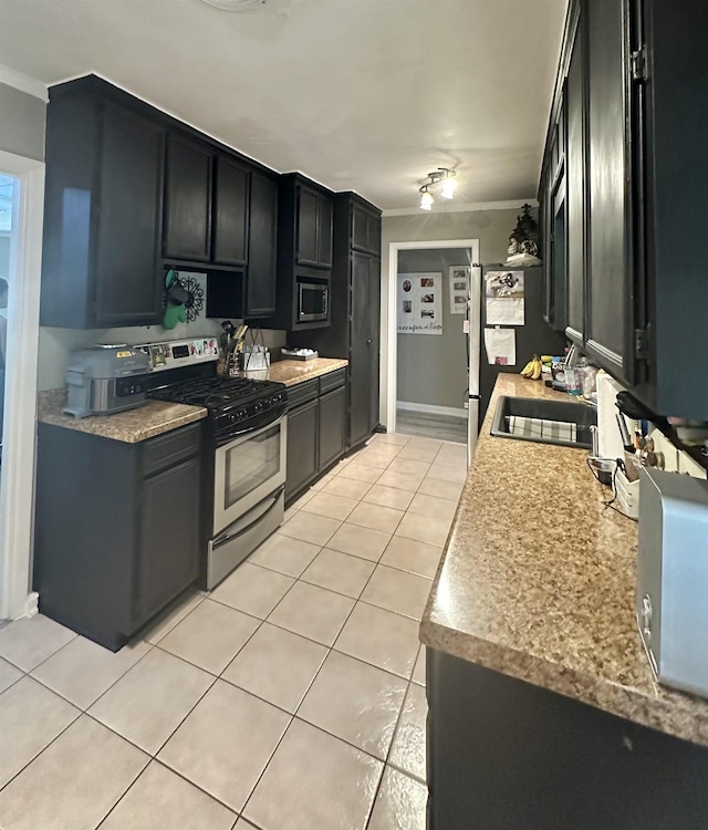 kitchen with light tile patterned floors, ornamental molding, sink, and appliances with stainless steel finishes