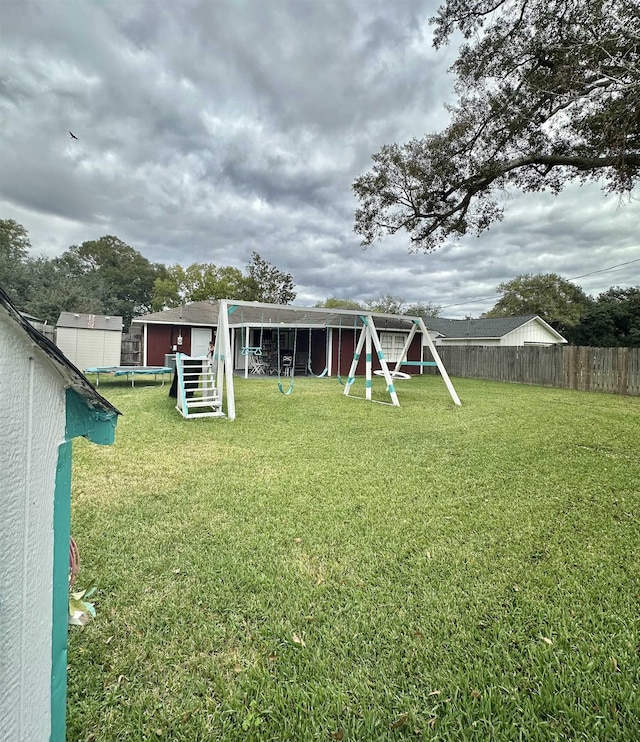 view of yard with a playground and a trampoline