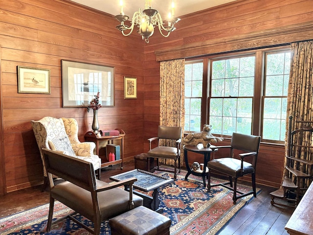 living area with a notable chandelier, wood walls, and dark hardwood / wood-style floors