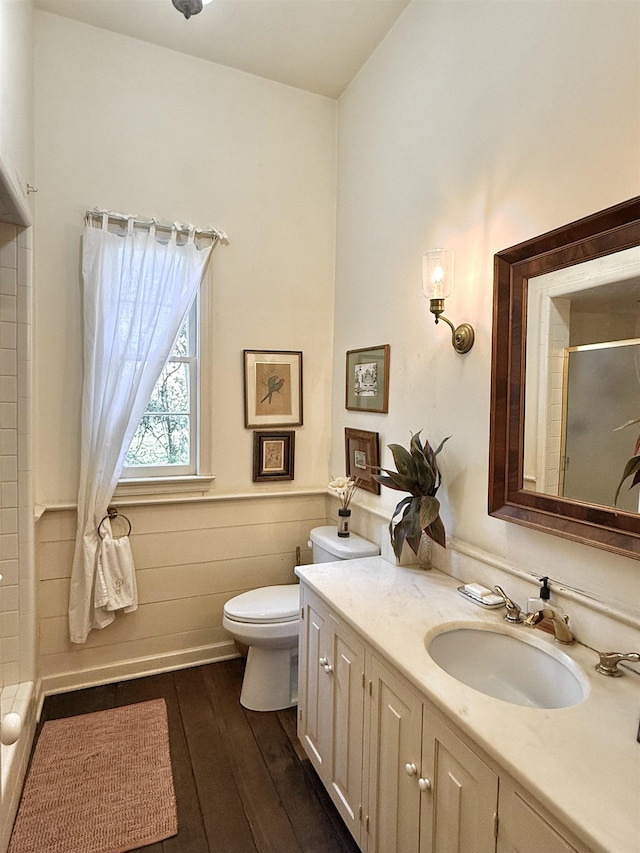 bathroom featuring toilet, hardwood / wood-style floors, vanity, and walk in shower