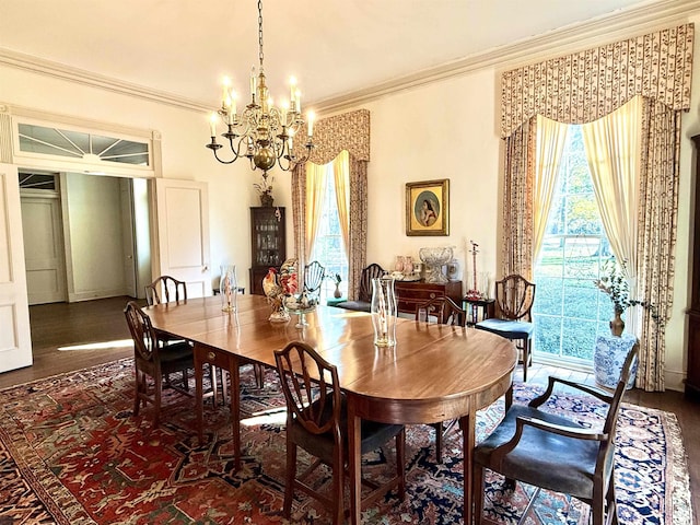 dining room featuring dark hardwood / wood-style flooring, ornamental molding, and a chandelier