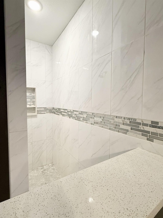 interior details with a tile shower