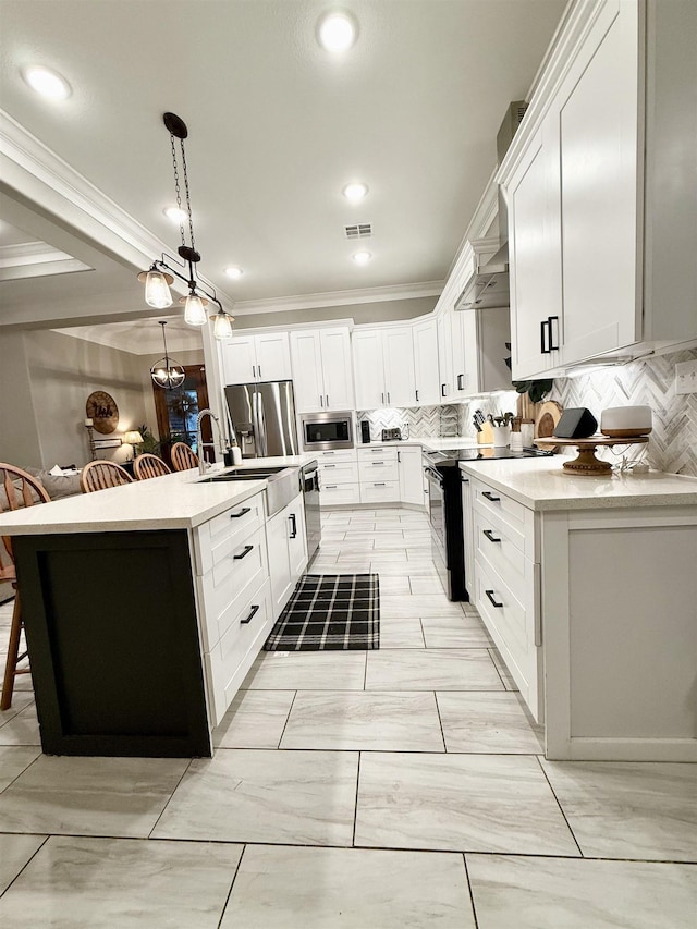 kitchen featuring a kitchen island with sink, stainless steel appliances, decorative backsplash, white cabinets, and decorative light fixtures