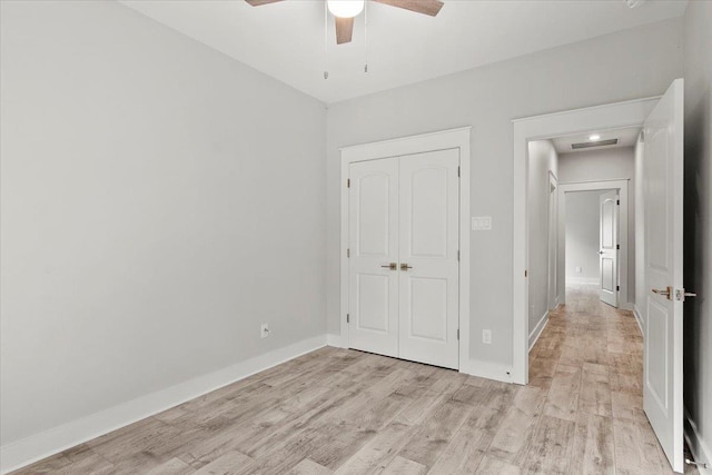 unfurnished bedroom featuring light wood-type flooring, a closet, and ceiling fan