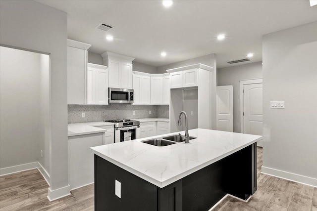 kitchen with sink, white cabinetry, an island with sink, and appliances with stainless steel finishes