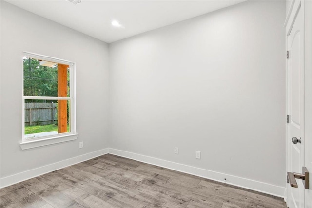 spare room featuring light hardwood / wood-style floors and a wealth of natural light