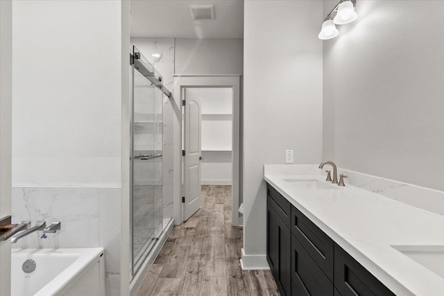 bathroom featuring separate shower and tub, vanity, and wood-type flooring