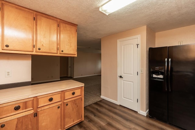 kitchen featuring dark wood-style flooring, baseboards, light countertops, a textured ceiling, and black fridge