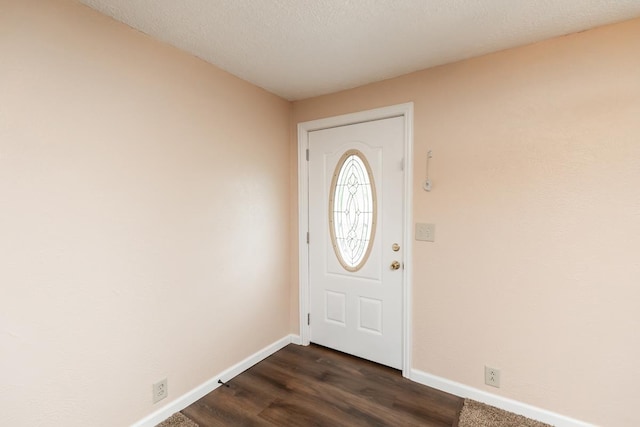 foyer featuring baseboards and dark wood-type flooring