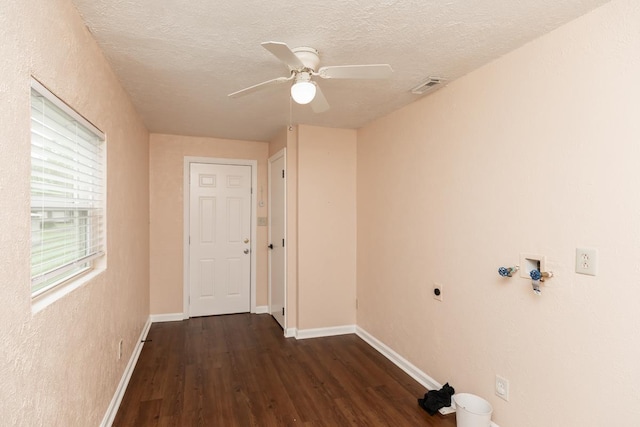 clothes washing area featuring a textured ceiling, baseboards, wood finished floors, hookup for an electric dryer, and visible vents