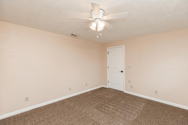 spare room featuring ceiling fan, a textured ceiling, visible vents, baseboards, and dark carpet