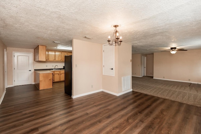 unfurnished living room featuring baseboards, visible vents, and a sink