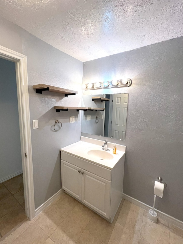 bathroom with tile patterned floors, vanity, and a textured ceiling