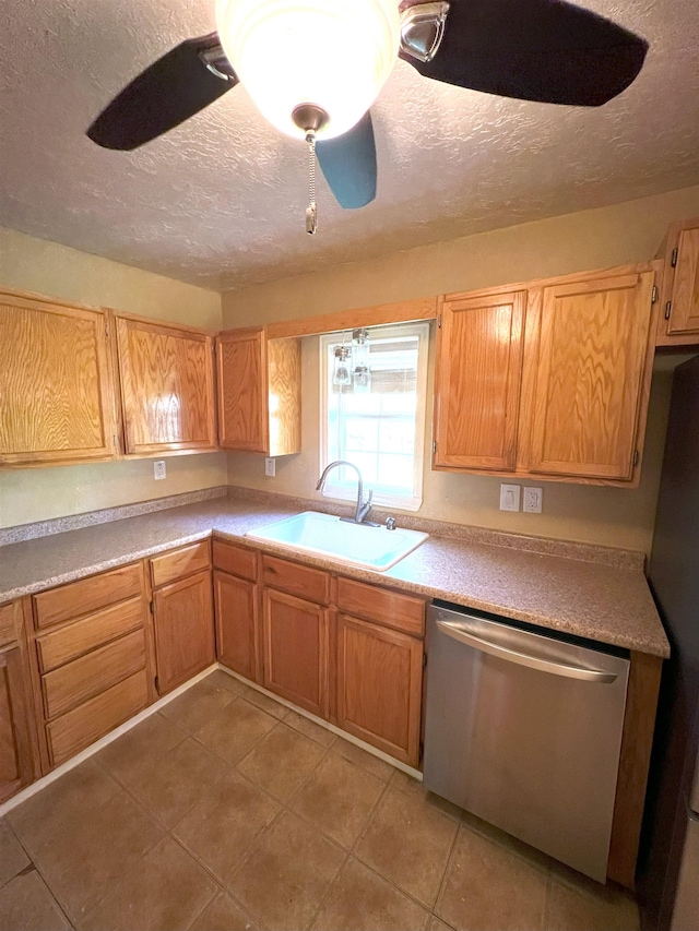 kitchen with sink, ceiling fan, a textured ceiling, light tile patterned flooring, and stainless steel appliances