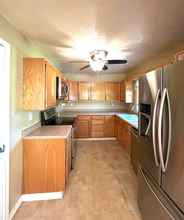 kitchen featuring ceiling fan, sink, a textured ceiling, and appliances with stainless steel finishes