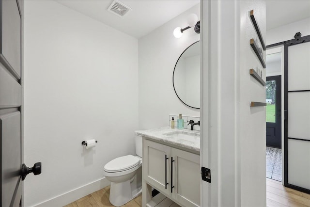11109 County Road 701, Buna, TX 77612 - bathroom with wood finished floors, toilet, vanity, and baseboards