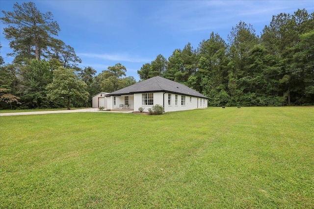 11109 County Road 701, Buna, TX 77612 - view of side of property featuring concrete driveway, a lawn, and a garage