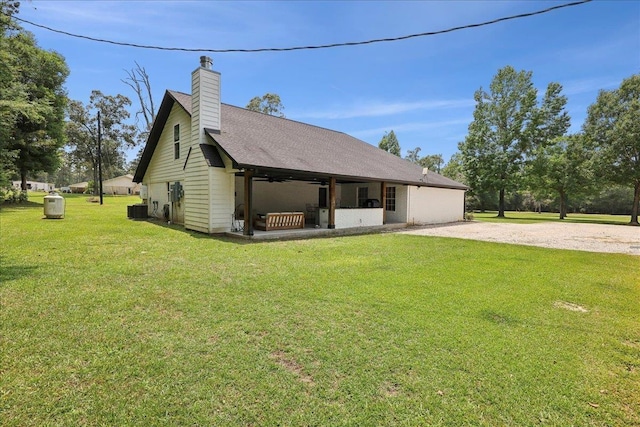 11109 County Road 701, Buna, TX 77612 - view of side of home featuring a yard, central AC unit, a ceiling fan, a chimney, and gravel driveway