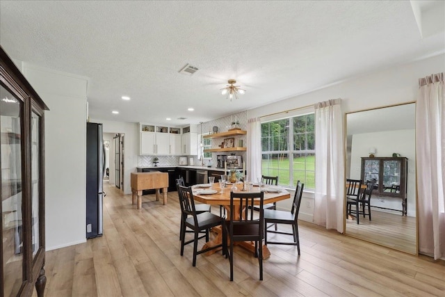 11109 County Road 701, Buna, TX 77612 - dining room with light wood-type flooring, a textured ceiling, and recessed lighting