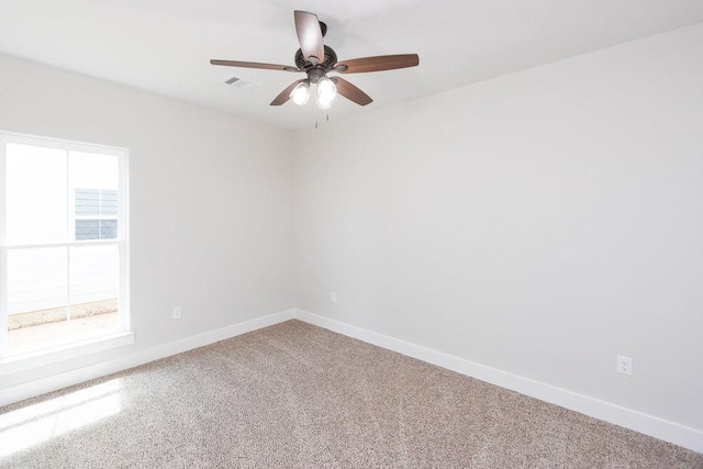 carpeted spare room featuring ceiling fan