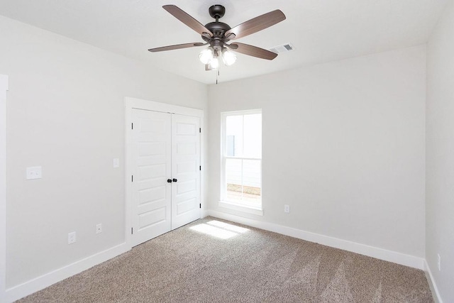 carpeted spare room with ceiling fan