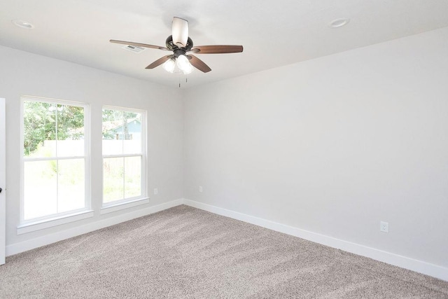 carpeted spare room featuring ceiling fan