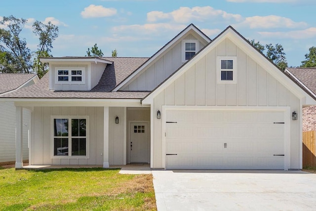 view of front of property featuring a porch, a front yard, and a garage