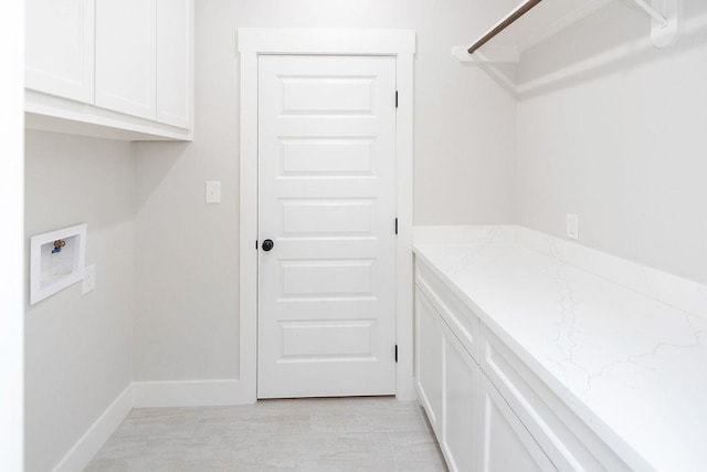 clothes washing area featuring washer hookup and cabinets