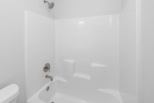 bathroom with toilet and washtub / shower combination