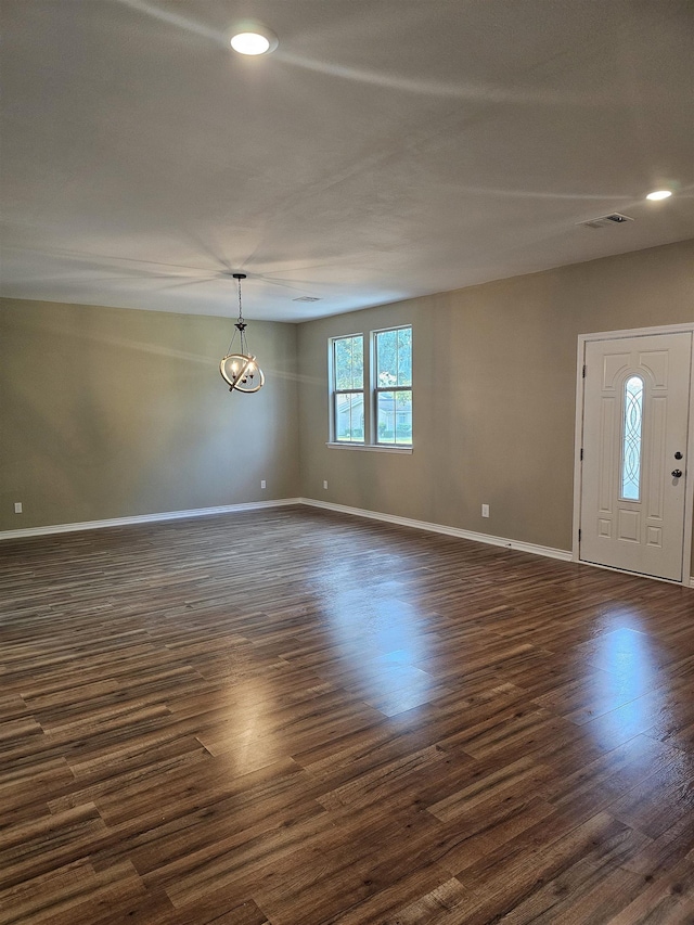 interior space featuring dark wood-type flooring and an inviting chandelier