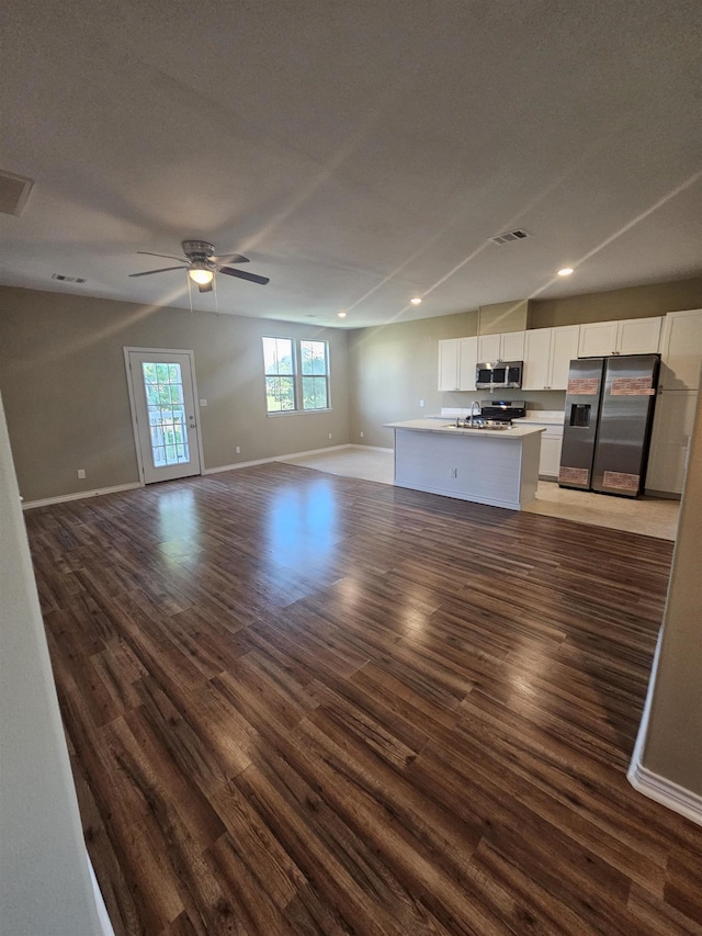 unfurnished living room featuring vaulted ceiling, ceiling fan, sink, and dark hardwood / wood-style floors