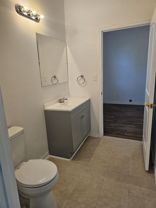 bathroom featuring tile patterned floors, vanity, and toilet