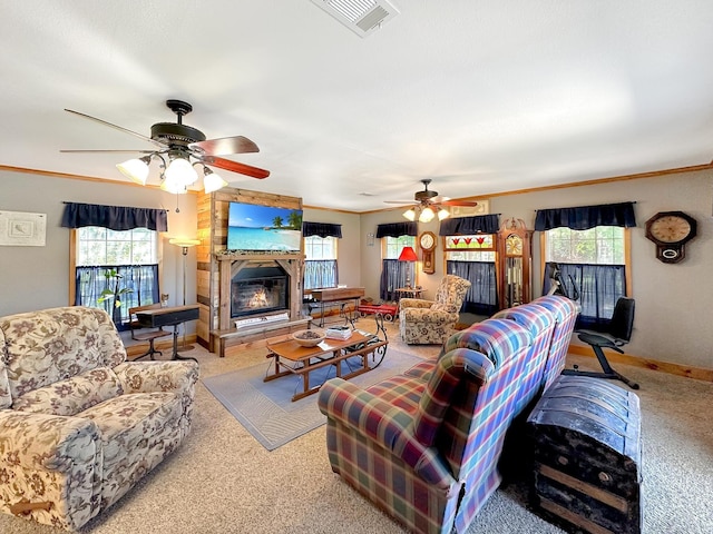 carpeted living room featuring a fireplace, a wealth of natural light, crown molding, and ceiling fan