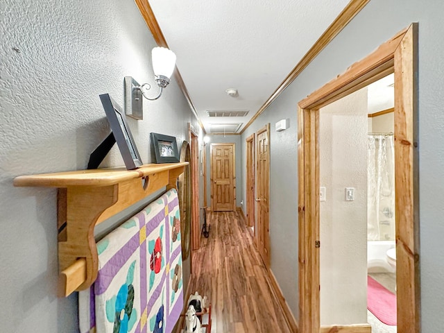 corridor featuring hardwood / wood-style floors and ornamental molding