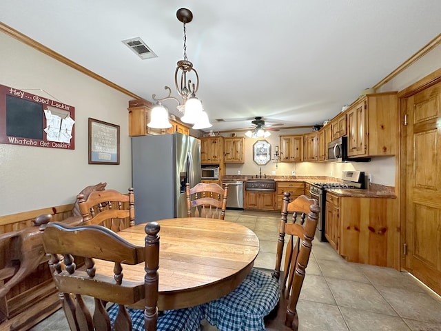 tiled dining space with ceiling fan with notable chandelier, ornamental molding, and sink