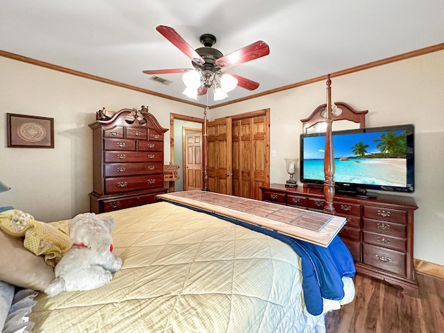 bedroom with hardwood / wood-style floors, ceiling fan, ornamental molding, and a closet