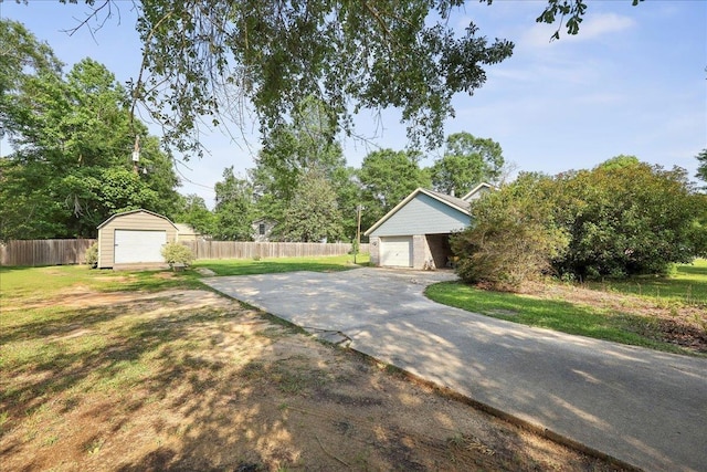 132 County Road 760, Buna, TX 77612 - exterior space featuring a shed, an outbuilding, fence, a front lawn, and a garage
