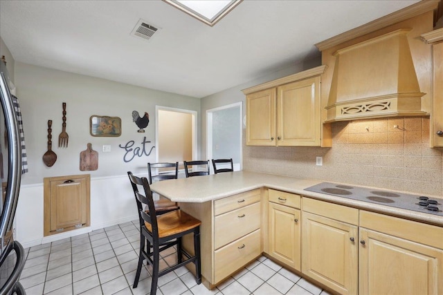 132 County Road 760, Buna, TX 77612 - kitchen with freestanding refrigerator, light brown cabinetry, black electric cooktop, visible vents, and a peninsula