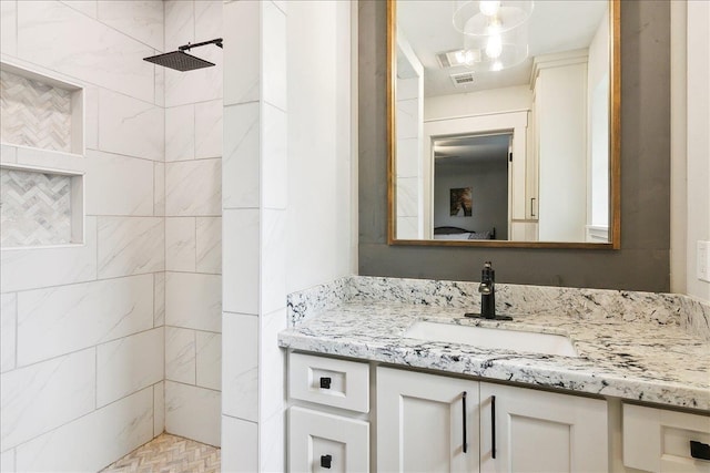 bathroom with vanity and a tile shower