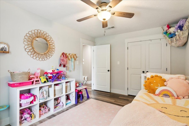 bedroom featuring ceiling fan, dark hardwood / wood-style flooring, and a closet