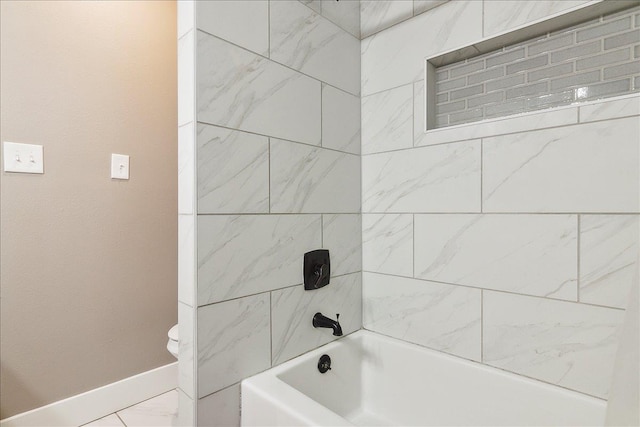 bathroom with tiled shower / bath combo and toilet