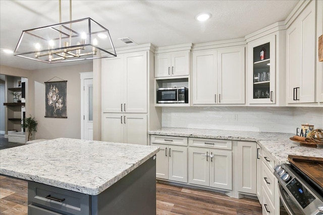 kitchen with stainless steel appliances, white cabinetry, tasteful backsplash, and pendant lighting