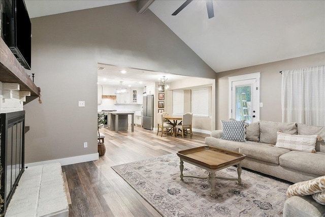 living room featuring beam ceiling, high vaulted ceiling, ceiling fan, a fireplace, and hardwood / wood-style floors