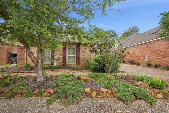 11 Regency Pl, Orange, TX 77630 - view of front of home featuring an attached garage, brick siding, concrete driveway, and roof with shingles