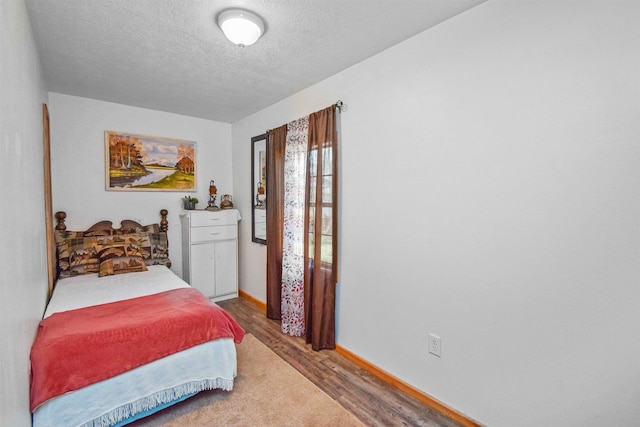 bedroom featuring hardwood / wood-style floors and a textured ceiling