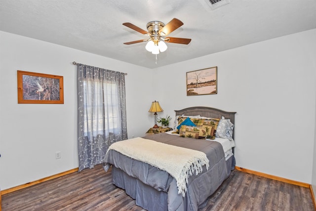 bedroom featuring ceiling fan, dark wood-type flooring, and a textured ceiling