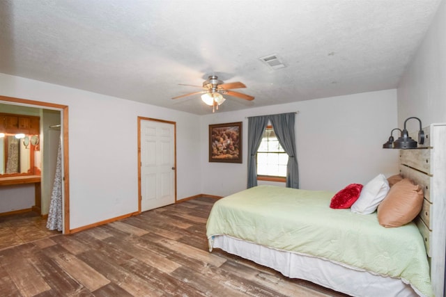 bedroom featuring ceiling fan, wood-type flooring, and a textured ceiling