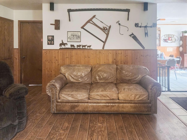 living room with dark hardwood / wood-style floors and wood walls
