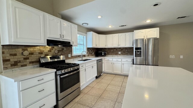 kitchen featuring a center island, light tile patterned floors, ceiling fan, stainless steel appliances, and white cabinets